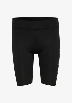 Person iført sorte atletikshorts med teksten "HUMMEL" på siden og sorte og blå sportssko, der står sidelæns.