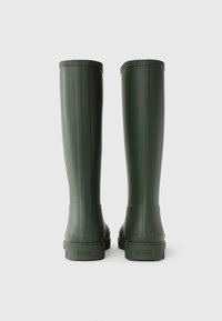 Green rubber knee-high boots with a smooth finish, ribbed design on the shaft, and a flat sole featuring the brand name on the heel.