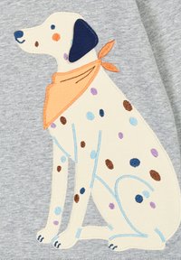 Gesticktes Baumwoll-Motiv zeigt einen sitzenden Hund mit einem hellcremfarbenen Körper, bunten Flecken, marineblauen Akzenten und einem orangefarbenen Halstuch.