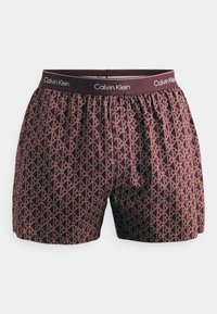 Tumši sarkanie Calvin Klein bokseršorti ar rozā ģeometrisku CK logo rakstu visā virsmā un ar zīmolu apstrādātu jostasvietu.