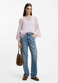Maglione lilla chiaro a maglia larga con scollo ampio, abbinato a jeans a gamba dritta color azzurro chiaro a vita alta. Borsa a tracolla marrone e mocassini.