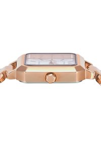 Montre rectangulaire en or rose avec un cadran transparent, des index horaires en argent et un bracelet en acier inoxydable texturé. Présente une couronne proéminente.