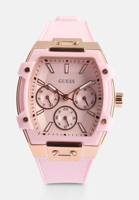Reloj con correa de silicona rosa que presenta una caja hexagonal en tono dorado, un dial texturizado rosa, tres subdiales y acentos en oro rosa.