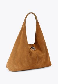 Borsa in camoscio marrone con manico a forma di mandorla e chiusura decorativa circolare sul davanti. Texture morbida e silhouette triangolare.