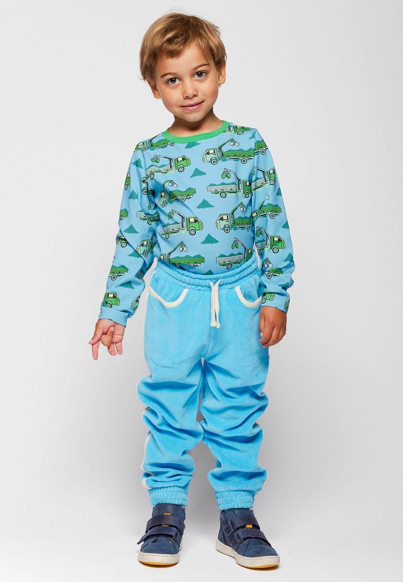 Chemise bleue à manches longues avec imprimé camion vert, associée à un pantalon de jogging bleu clair doux doté d'un cordon de serrage et de poignets aux chevilles.