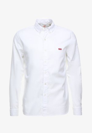 Camicia bianca a maniche lunghe con bottoni, colletto con bottone e piccolo logo rosso Levi's sul petto sinistro.