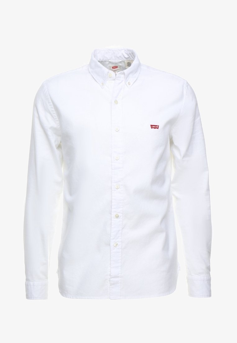 Chemise blanche à manches longues boutonnée avec col boutonné et petit logo rouge Levi's sur la poitrine gauche.