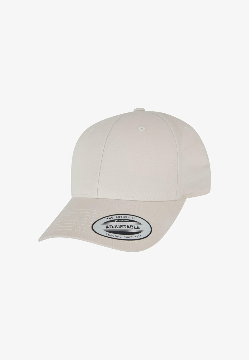 Adjustable cap in light beige fabric with a smooth texture, featuring a curved brim and a circular tag displaying "ADJUSTABLE."