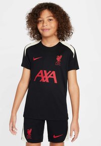 Mlađi dres Liverpool FC uključuje crnu kratku majicu s crvenim logotipom i natpisom "AXA", uparen s crnim šortsevima i krem detaljima.