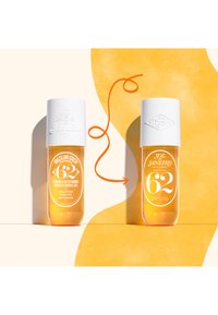 Due bottiglie trasparenti di profumo spray con tappi bianchi. La bottiglia a sinistra presenta un'etichetta con testo ed elementi decorativi in arancione e bianco.