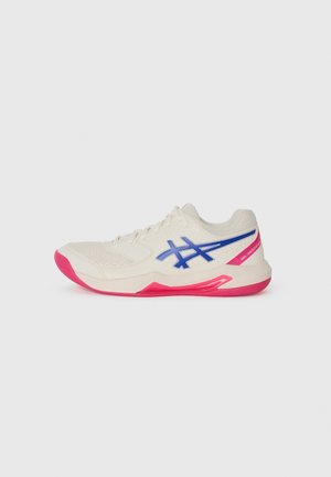 Weißer Sportschuh mit blauem Logo und pinken Akzenten an Sohle und Ferse, dargestellt auf einem einfarbigen hellgrauen Hintergrund.