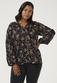 Sort bluse med blomstermønster i nuancer af pink og hvid. Har V-halsudskæring, lange pufærmer og en afslappet pasform. Blødt stof.