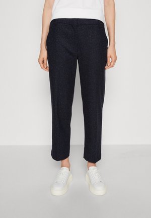 Navyblauwe, gestructureerde broek met een relaxte pasvorm, omgeslagen zoom, zijzakken, gedragen met witte sneakers. Smalle tailleband met riemlussen.