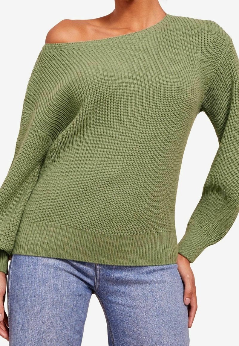 Pull tricoté vert à épaules dénudées avec une texture côtelée et des manches longues, assorti à un jean bleu clair. Le tissu semble doux et épais.