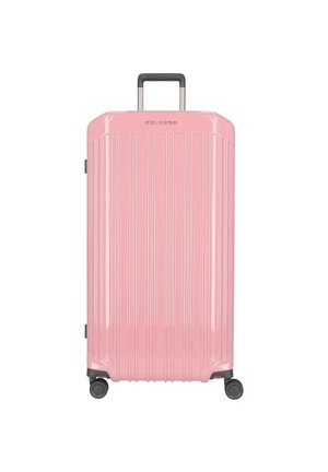Pink hardshell suitcase with vertical grooves, telescopic handle, four wheels, and a glossy finish for easy mobility.