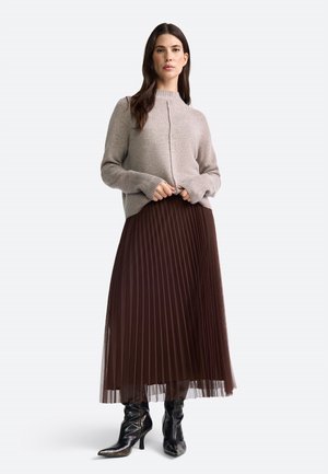 Light gray knit sweater with a high neckline, paired with a brown pleated maxi skirt and black heeled boots. Smooth textures and layered fabric.