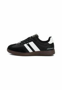 Black sneakers with white stripes, suede and synthetic materials, round toe, low profile, textured brown rubber sole, flat laces, minimal branding.