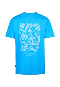 Camiseta de algodón color turquesa con mangas cortas, que presenta un gráfico blanco de flores y animales en la parte posterior y un logo cerca del dobladillo.