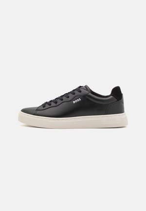 Zwarte lage leren sneaker met zwarte veters, witte zool en het "BOSS"-logo aan de zijkant en hiel, zijaanzicht.