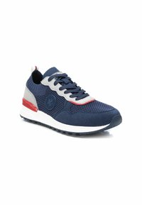 Zapatillas deportivas azul marino con parte superior de malla y gamuza, acentos grises, detalles rojos, cordones planos y una suela blanca con textura.