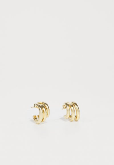 Boucles d'oreilles en ton doré avec trois designs de cerceaux entrelacés, finition lisse et fermoir clip-on. Esthétique minimaliste et moderne.