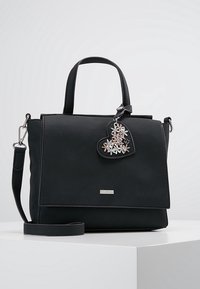 Svart, texturerad handväska med rektangulär form. Har två korta handtag, en avtagbar axelrem och en hjärtformad blomsterberlock.