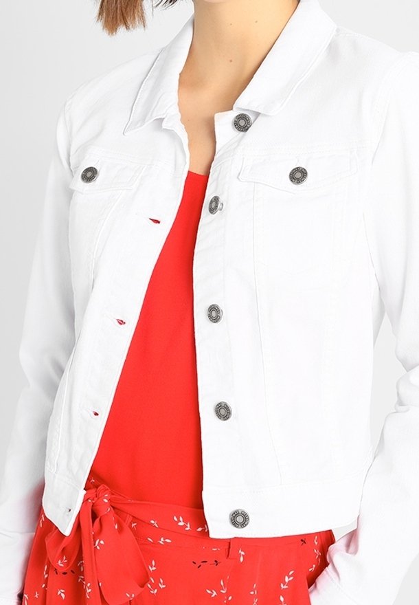 Vit denimjacka med krage, framknäppning och två bröstfickor. Bärs över en röd topp med en blommig mönstrad kjol.