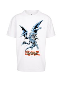 Hvid bomulds t-shirt med et blå- og sort dragegrafik med skarpe vinger og tænder, samt "Yu-Gi-Oh!" teksten i fed orange og sort.