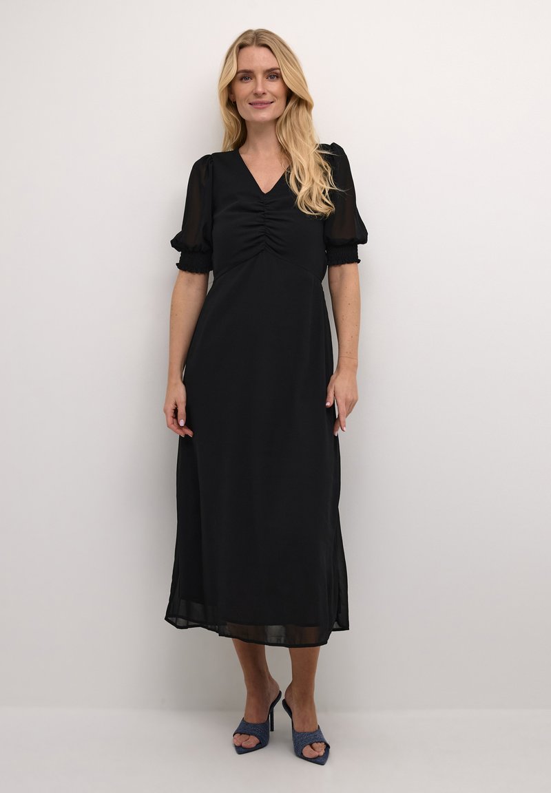 Must mustriga kleit lühikeste puffvarrukatega, kortsustatud bodice ja V-kaelusega. Sile kangas voolava siluetiga ja läbipaistvad detailid hemmed.