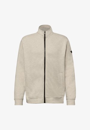 Giacca beige chiaro con zip, collo alto, maniche lunghe, due tasche laterali e cerniera nera che corre lungo il centro frontale.