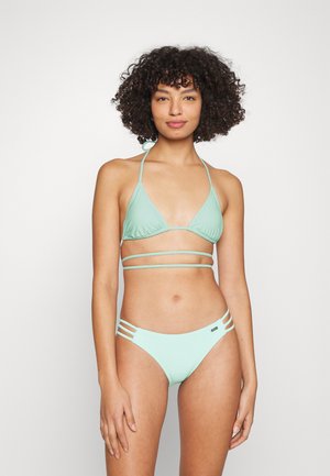 Bikini vert menthe avec un haut triangulaire à bretelles réglables et des accents sur les côtés, associé à un bas taille basse assorti avec des découpes.