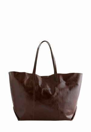 Grand sac fourre-tout en cuir marron avec une texture lisse, deux longues anses et un bord supérieur légèrement effilé. Il présente un design minimaliste.