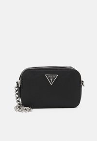 Černá obdélníková crossbody taška Guess se stříbrným řetízkovým popruhem a trojúhelníkovým kovovým logem na strukturovaném povrchu.