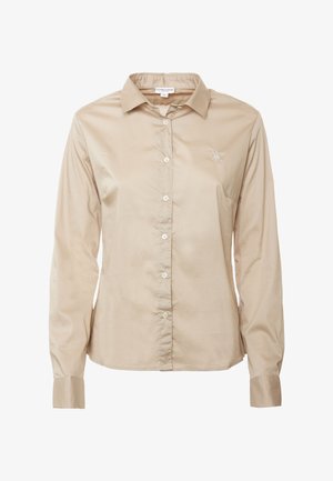 Camicia beige a maniche lunghe con bottone realizzata in tessuto morbido, dotata di colletto, sei bottoni frontali e un piccolo logo ricamato sul petto.