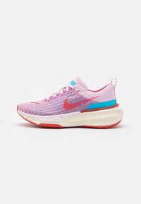 Běžecká obuv Nike s pleteným svrškem v růžové a modré barvě, červenými akcenty a silnou bílou podešví. Obsahuje zaoblenou špičku a šněrování.