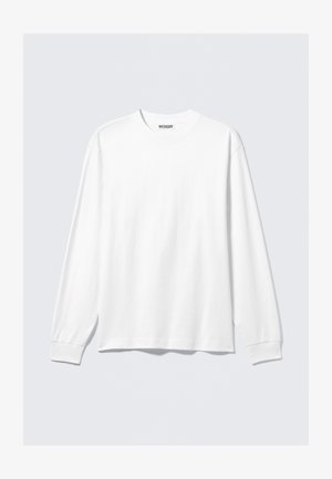 Hvit langermet crewneck skjorte med ribbestrikkede mansjetter og en liten merkeetikett "WEEKDAY" inni halsåpningen.