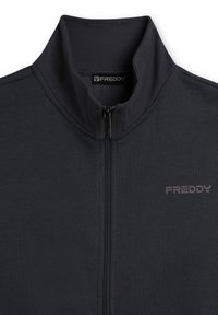 Chaqueta gris oscuro con cremallera, hecha de material de forro polar. Cuenta con un cuello alto y una marca sutil en el área del pecho izquierdo. Textura suave.