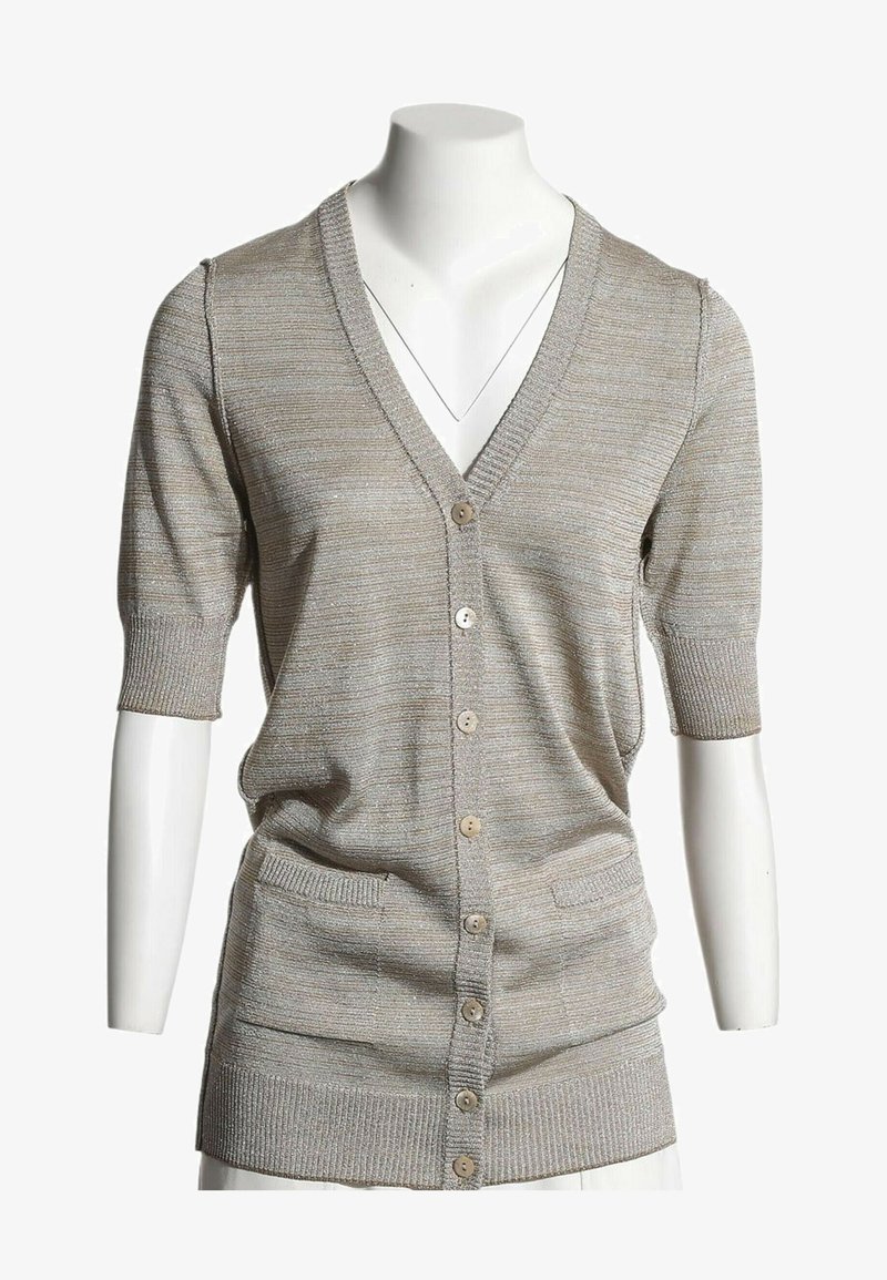 Cardigan beige à manches courtes avec boutons, deux poches avant et poignets côtelés sur un buste de mannequin blanc.
