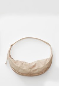 Borsa a spalla beige in morbido tessuto con forma arrotondata, tracolla regolabile e chiusura a zip. Tessuto liscio con dettagli di cucitura sottili.