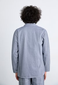 Long-sleeve shirt in blue and white striped pattern, features a collar, relaxed fit, and is made from soft cotton fabric.
