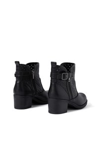 Stivaletti neri in pelle con design perforato, chiusura con zip laterale e tacco a blocco di 6,5 cm con dettagli in fibbia sulle cinghie.