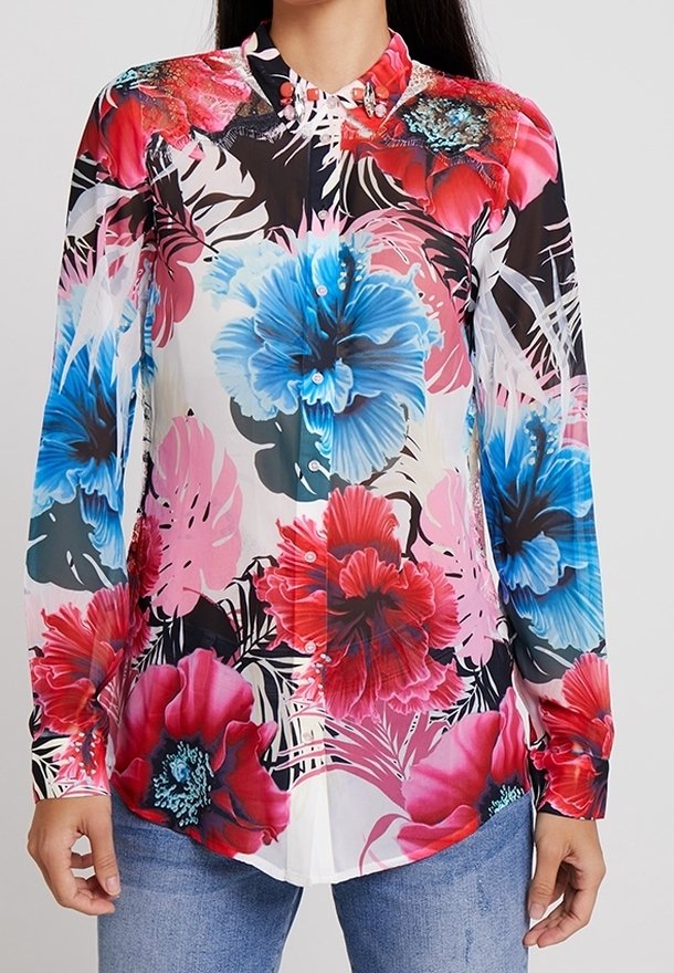Chemise à boutons avec un motif floral de fleurs bleues et rouges sur un fond blanc translucide. Manches longues, col et ourlet droit.