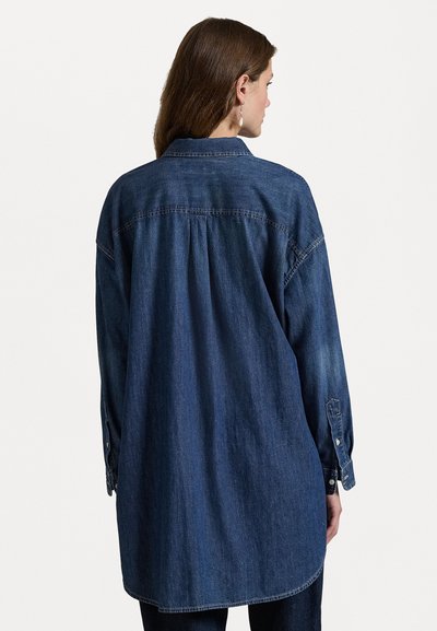 Camicia di denim blu scuro con una vestibilità comoda, piega sul retro e maniche lunghe. Presenta polsini con bottoni e un colletto classico.