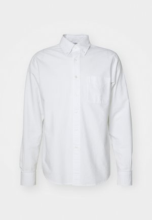 Fehér gombos ing, pamutból készült, hegyes gallérral, hosszú ujjal, egyetlen mellzsebbe helyezhető és finom, világos textúrával.