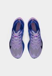 Ζευγάρι μωβ και μπλε παπούτσια για τρέξιμο Nike, ορατά από πάνω σε λευκό φόντο, με δεμένα κορδόνια και εμφανή λογότυπα Nike.