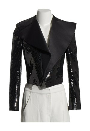 Schwarze, kurze Paillettenjacke mit breitem Satinrevers, präsentiert an einer weißen Schaufensterpuppe mit weißen Hosen.