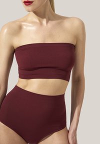 Completo bordeaux a due pezzi con top senza spalline e pantaloni a vita alta. Tessuto liscio con un design aderente e dettagli a coste.