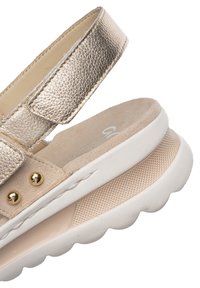 Bežovo-zlatá sandála s otevřenou špičkou a nastavitelným kovovým řemínkem, zlatými cvočky, měkkou stélkou a strukturovanou bílou platformovou podrážkou.