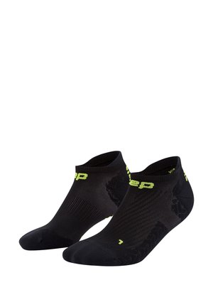 Calze sportive nere con un motivo testurizzato, lunghezza alla caviglia con una vestibilità aderente e accenti in giallo brillante per una maggiore visibilità.