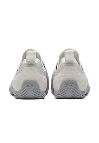 Szare buty sportowe o gładkim wykończeniu, z zamszowymi akcentami i wyraźnym logo na pięcie. Niskie z elastyczną podeszwą i tekstylnym cholewką.